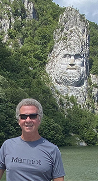 Tourist in front of rock statue of Decebalus